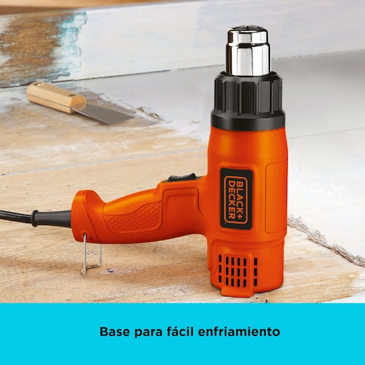 Photo of BLACKDECKER HG1500 orange heat gun with stand, shown on a wooden work surface with a scraper tool.
