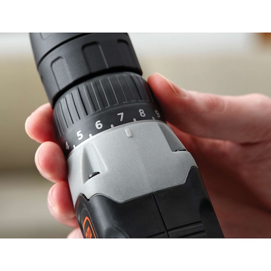 Close-up photo of BLACKDECKER BCD702C1 cordless drill torque adjustment dial being set by hand.