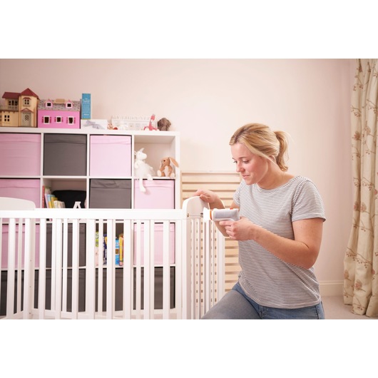 BLACKDECKER BCRTA01 baby monitor in nursery, woman holding device near crib with pink and grey storage bins.