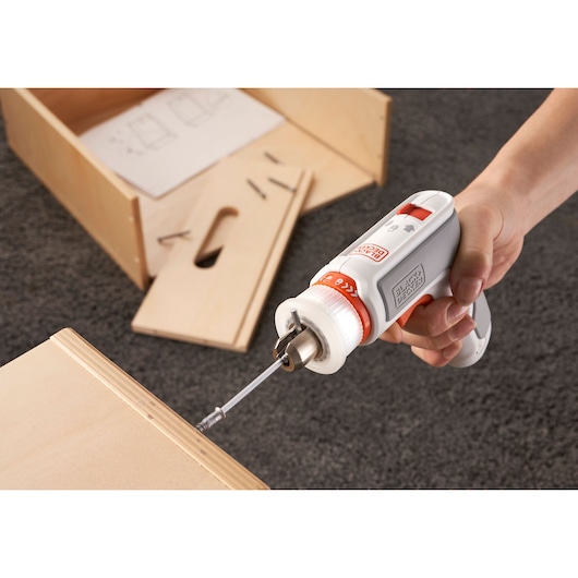 Photo of BLACKDECKER BCRTA01 cordless screwdriver in use assembling wooden furniture on carpeted floor.