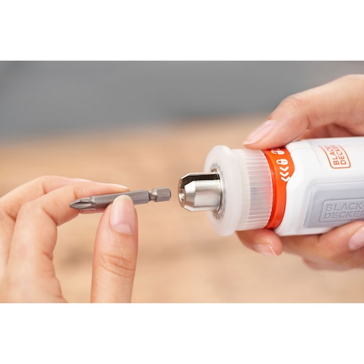 Photo of BLACKDECKER BCRTA01 screwdriver with hand holding a drill bit near the chuck.