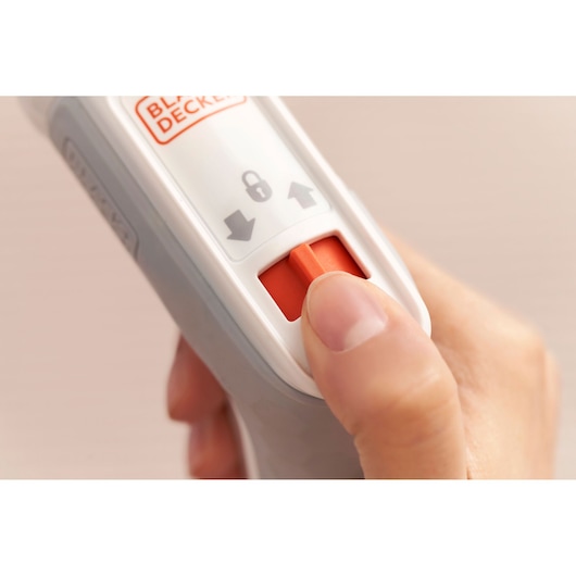 Photo of BLACK+DECKER BCRTA01 tool handle with thumb pressing orange safety lock switch.