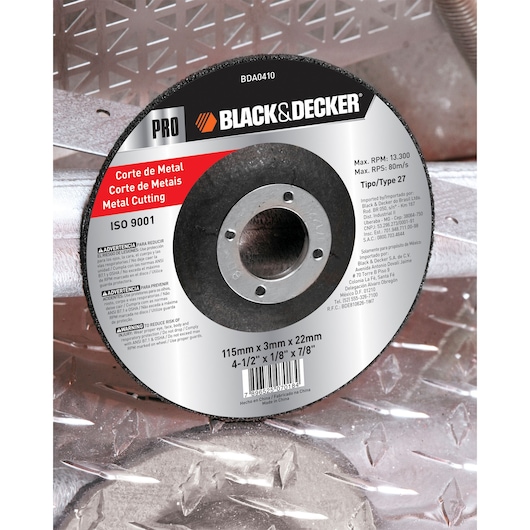 A BLACK+DECKER branded metal cutting disc with product information printed on the label, including specifications such as 115mm x 3mm x 22mm (4-1/2 x 1/8 x 7/8 inches), warnings, and safety instructions. The disc is positioned on a metallic, industrial background.