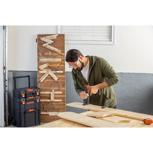BLACKDECKER BDCDMT1206KITC cordless tool kit used in woodworking, with portable storage boxes and wooden boards.