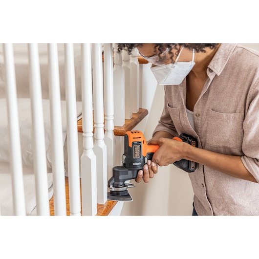 Photo of person sanding stair railing with BLACKDECKER BDCDMT1206KITC cordless multi-tool.
