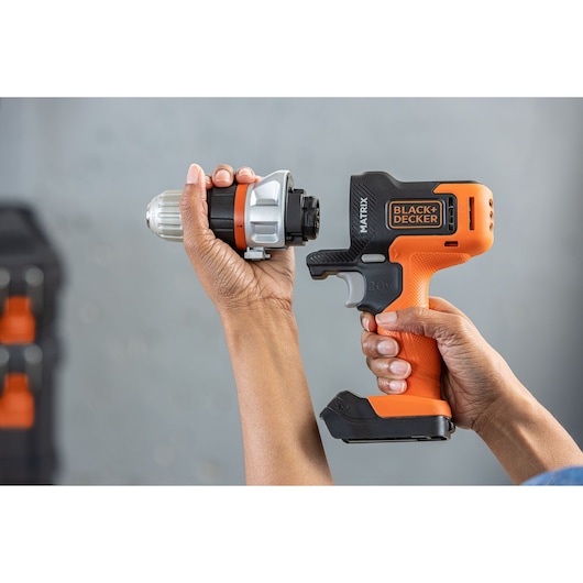 Photo of BLACK+DECKER BDCDMT1206KITC cordless drill with orange and black handle and detachable drill head held in hands.