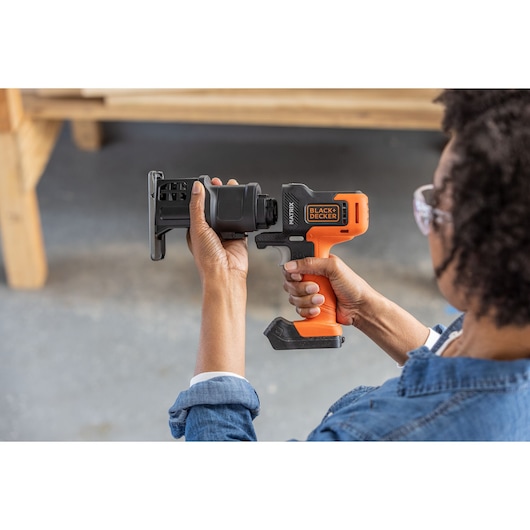 Photo of BLACKDECKER BDCDMT1206KITC cordless power tool with orange handle and black attachment held in hands.
