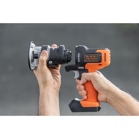 Photo of BLACKDECKER BDCDMT1206KITC cordless tool with orange and black grip being held by two hands.