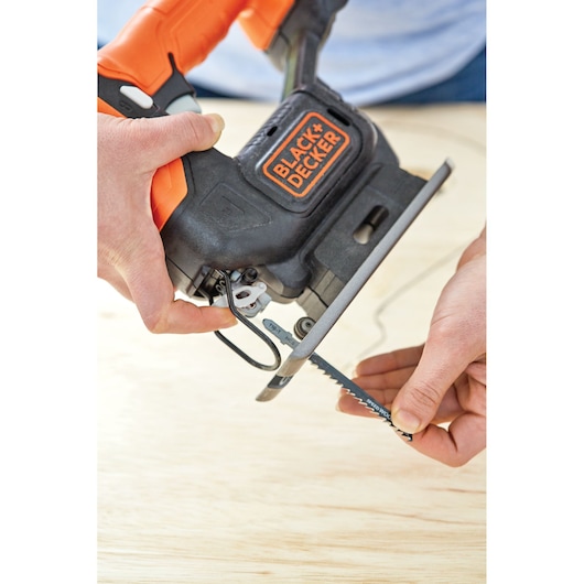 Photo of BLACK+DECKER BDCK502C1 jigsaw with orange and black handle, person inserting blade into tool.