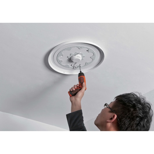 Black+Decker BDCS36F cordless screwdriver used to install ceiling light fixture, photographed from below.