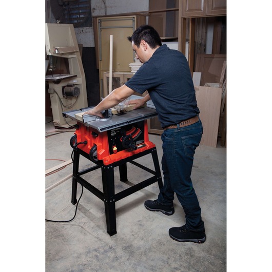 Photo of BLACKDECKER BDTS1800 table saw in use on stand, cutting wood in a workshop.