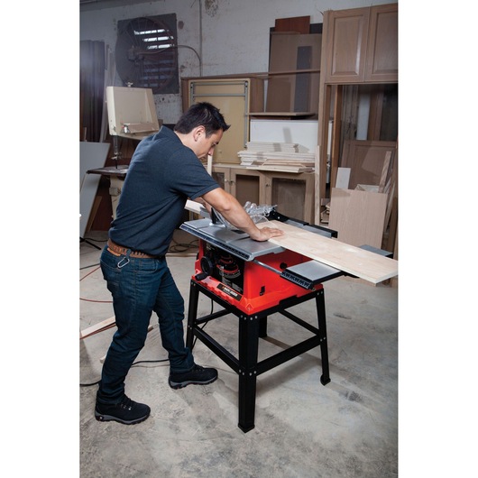 Photo of BLACKDECKER BDTS1800 table saw cutting wood in a workshop, worker operating the saw.