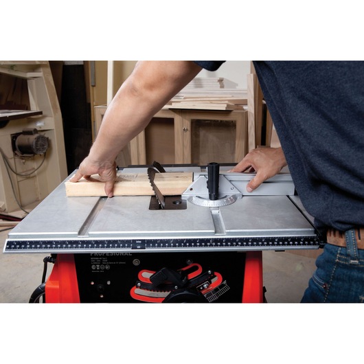 BLACKDECKER BDTS1800 table saw in use, cutting a wooden plank, front angle.