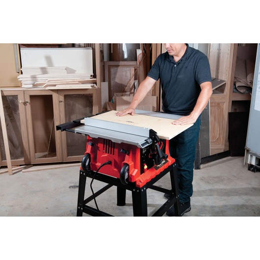 BLACKDECKER BDTS1800 table saw in use cutting wood in a workshop setting.
