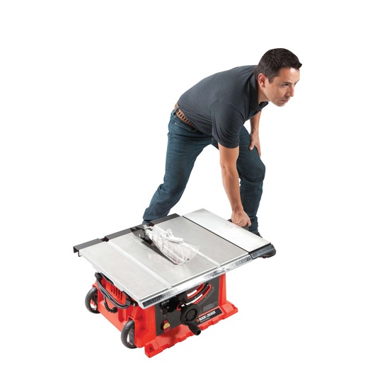 BLACKDECKER BDTS1800 table saw with silver top and red base, shown from front angle with person adjusting the tool.