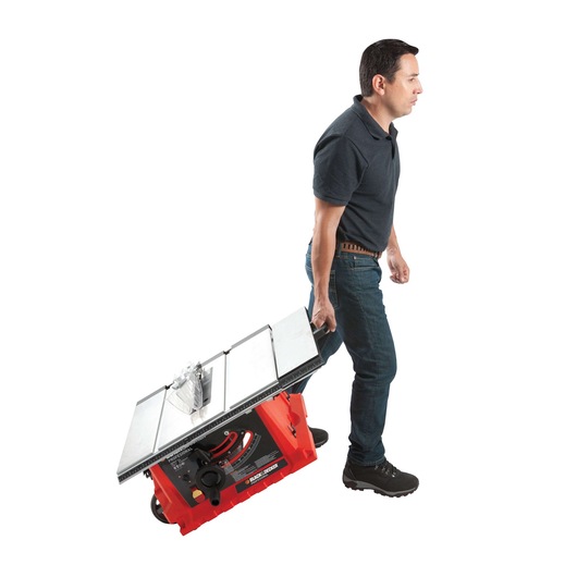 Photo of a person pulling a BLACKDECKER BDTS1800 table saw with wheels, side view on white background.