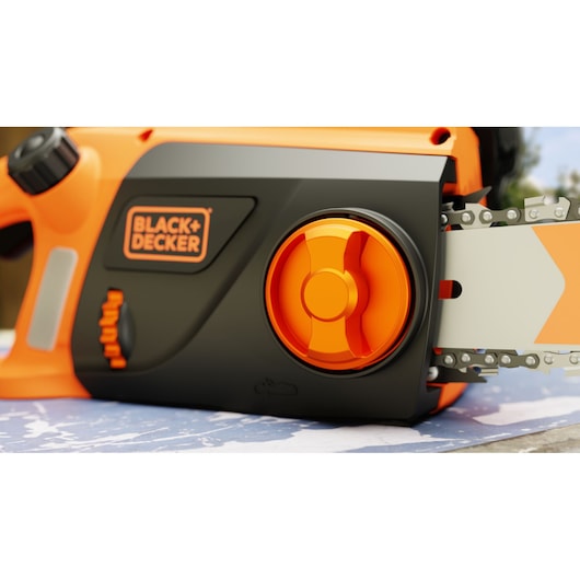 BLACK+DECKER BECS2245 chainsaw close-up, showing orange and black body, tension knob, and chain detail.