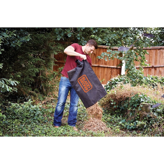 Photo of BLACKDECKER BV25 leaf blower collection bag being emptied onto garden ground.