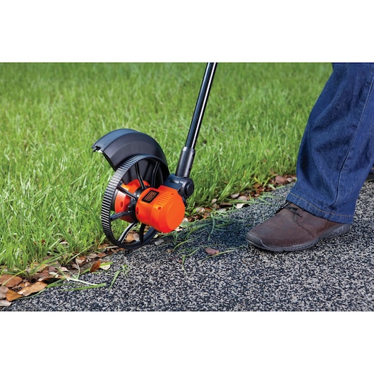 Photo of BLACKDECKER GL600N lawn edger trimming grass along a sidewalk.