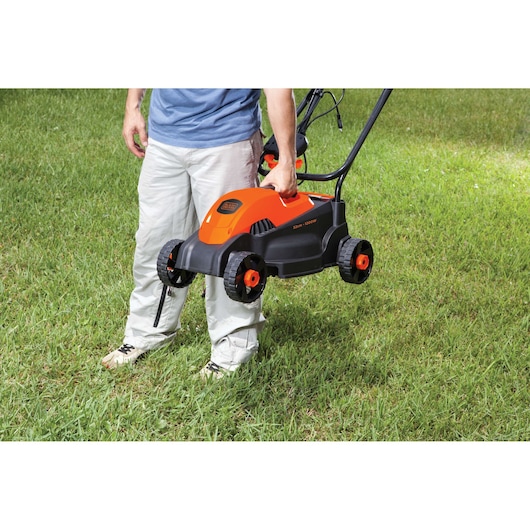 BLACKDECKER GR1000 electric lawn mower carried by a person on grass, compact orange and black design.