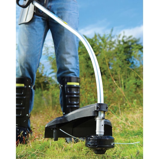 BLACKDECKER GST26 string trimmer in use outdoors, close-up of cutting head and shaft.