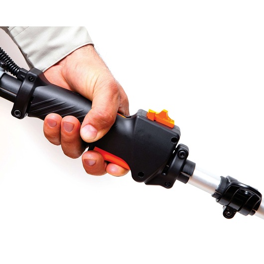 Photo of BLACKDECKER GST26 trimmer handle with hand gripping black and orange controls on white background.