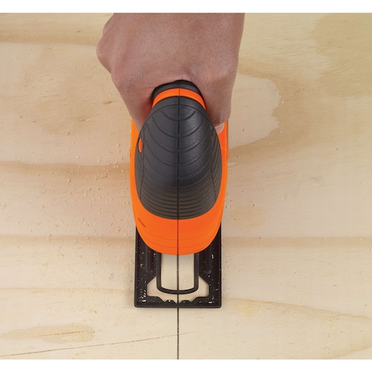 BLACKDECKER KS501 jigsaw cutting wood, top view showing orange and black handle.