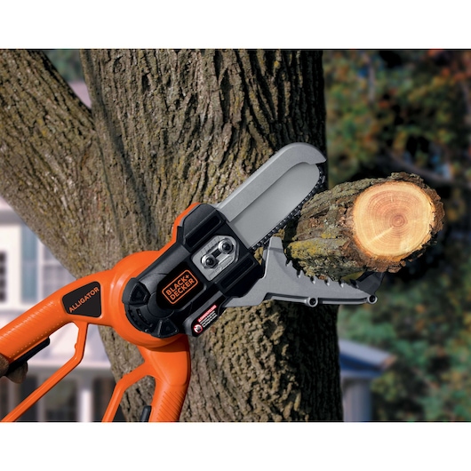 BLACKDECKER LLP120 cordless alligator lopper cutting a tree branch outdoors.