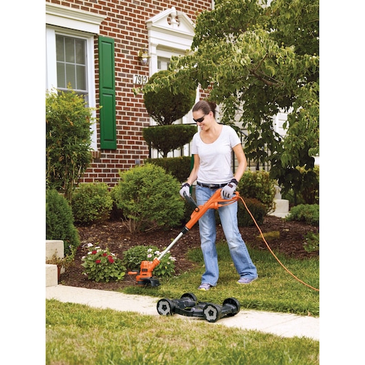 BLACKDECKER MTE912 corded lawn trimmer with detachable mower attachment in garden use.