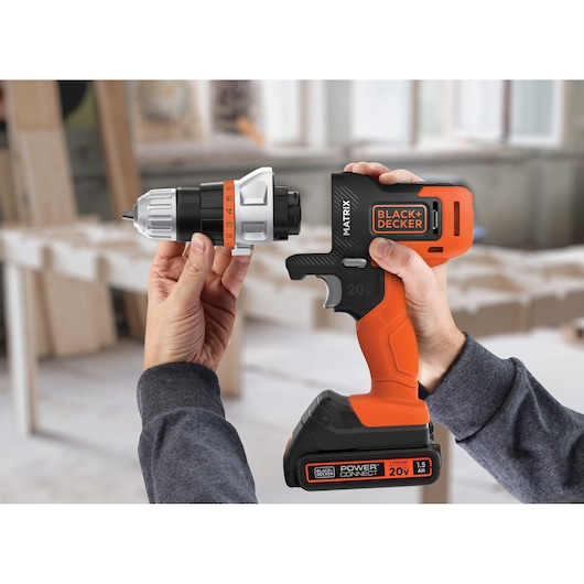 Photo of BLACKDECKER MTX20K6A cordless drill with orange and black design, detachable head, shown in a workshop.