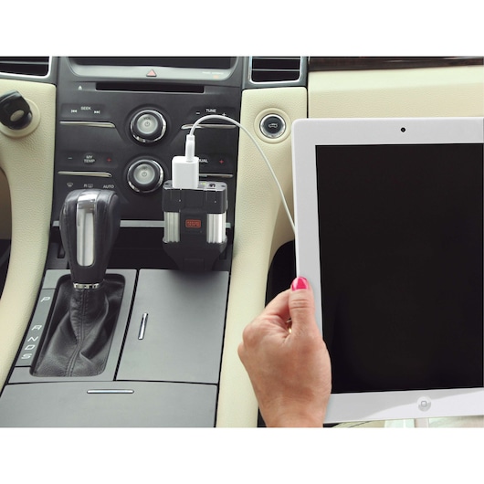 BLACKDECKER PI100LA power inverter plugged in car charging tablet, center console angle.